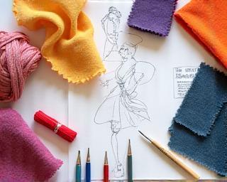 Textile design sketches next to various colorful material samples and threads